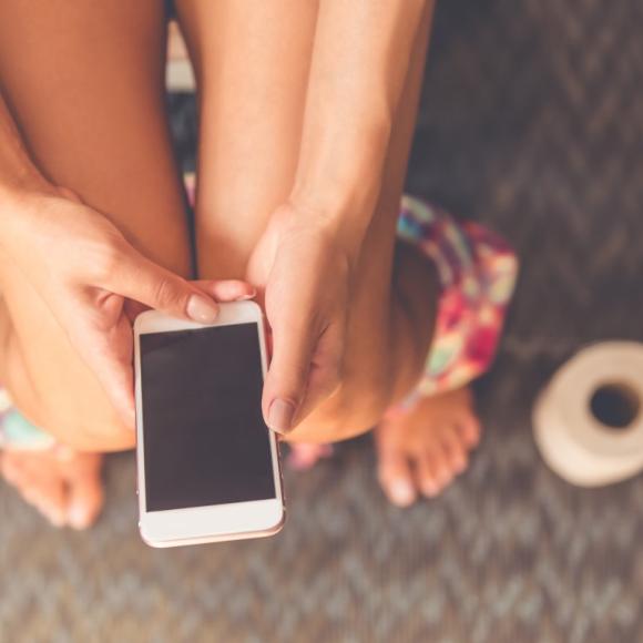 persoon met smartphone op toilet