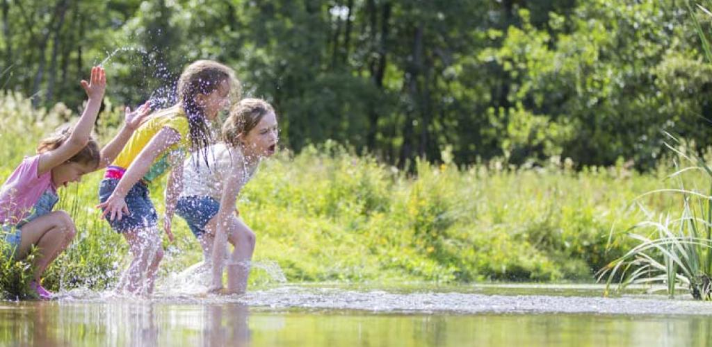 Spelende kinderen aan de oever van een beek